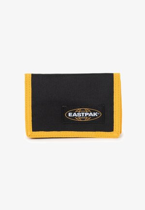 Black fabric wallet with yellow stitching and accents, featuring an Eastpak logo patch on the front. Compact, rectangular shape.