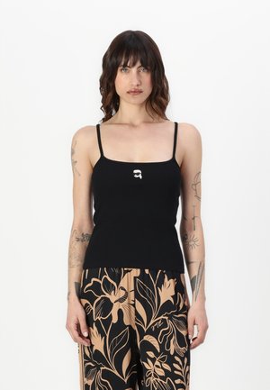 Black ribbed tank top with thin straps, featuring a small white logo centered on the chest. The fabric has a smooth texture.