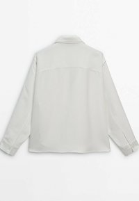 Camicia lunga manica grigia chiara con colletto a fodero, polsini con bottone, texture liscia e cucitura a yoke sulla schiena.