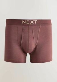 Punaharmajat bokserialushousut, joissa "NEXT"-logo vyötärönauhassa ja vahvistetut saumat etuosassa.