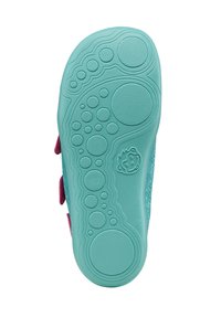 Una suela de zapato turquesa con burbujas y círculos texturizados, con un acento rosa cerca del lado, diseñada para proporcionar agarre y comodidad.