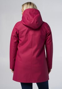 Waterdichte roze regenjas met een capuchon, voorzien van een gladde textuur en lange mouwen, die tot halverwege de bovenbenen reikt met eenvoudige stikseldetails.
