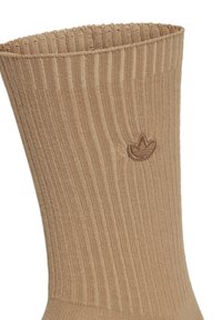 Smeđi rebrasti čarapa s teksturiranom površinom, s malim utisnutim logotipom blizu vrha. Tkanina na vrhu je elastična za bolje prianjanje.