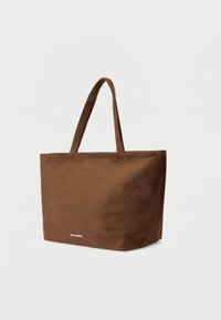 Geantă tote maro din pânză cu două mânere, formă dreptunghiulară, textură netedă și un mic logo alb în partea de jos.