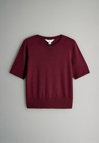 Bordeauxrotes kurzärmliges Sweater aus weicher Strickware mit rundem Halsausschnitt und geripptem Saum, flach vor einem hellen Hintergrund präsentiert.
