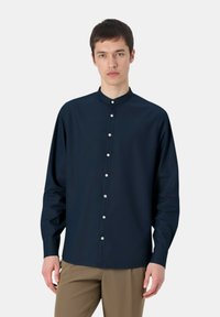 Camicia a maniche lunghe blu navy con colletto alla cinese, caratterizzata da chiusura con bottoni e tessuto liscio. Silhouette aderente, design minimalista.