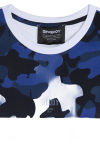 Camiseta de camuflaje azul con cuello blanco, hecha de una tela suave. Presenta el logotipo "FREDDY" impreso en negro en la parte inferior del frente.