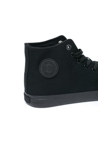 Mustad musta kõrge pealsega sneaker, mis on valmistatud kanvasest ja kummist tallaga. Omab ümmargust logo ja metallesiseid mustade paeltega.