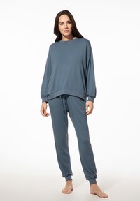 Lichtblauw loungewear-set gemaakt van zacht materiaal; bevat een loszittend sweatshirt met verlaagde schouders en joggerbroek met taps toelopende manchetten.