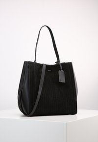 Černá ramenní taška vyrobená z texturované látky s vertikálními pruhy, s hladkými koženými akcenty a odnímatelnou visačkou s logem.