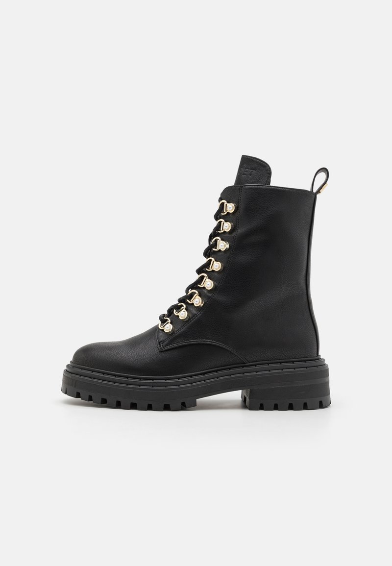 Bottes en cuir noir à lacets avec œillets dorés, semelle épaisse noire, surface texturée et tirette à l'arrière pour un enfilage facile.