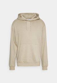 Sudadera de algodón color beige con un bolsillo frontal, capucha con cordones y puños acanalados, que presenta una textura suave y un diseño de ajuste relajado.