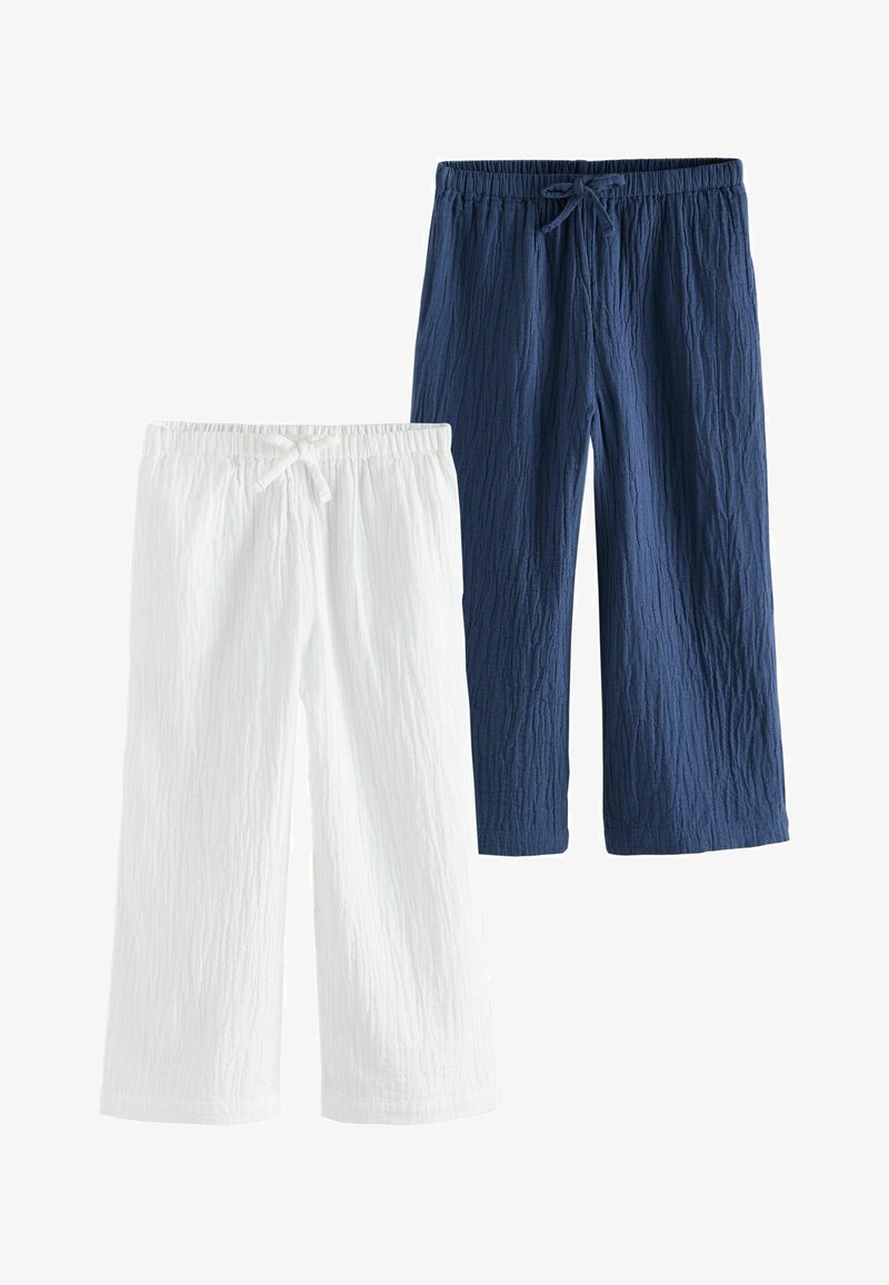 Deux paires de pantalons en coton texturé, un blanc et un bleu marine, tous deux avec taille élastique et cordons de serrage.