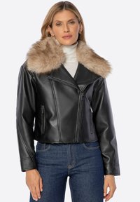 Giacca cropped in pelle nera con colletto in pelliccia sintetica beige, dotata di tasche con zip e design a revers.