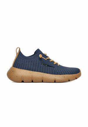 Marineblauwe gebreide sneaker met dikke beige gevlekte zool, beige veters en treklus, zijaanzicht op witte achtergrond.