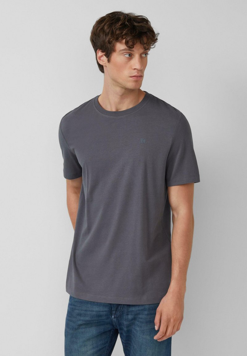 Grijze katoenen T-shirt met een ronde hals, korte mouwen en een subtiele logo-accent op de borst. Heeft een zachte, comfortabele textuur.