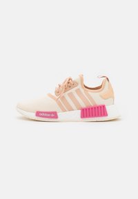 Adidas NMD-sneakers i ljus persikofärgad mesh med tre överlagda ränder. Har en rosa hälkappa, vit mellansula och texturerad rosa yttersula.