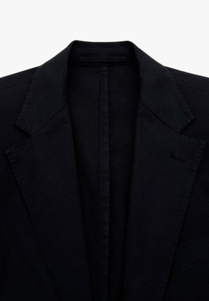 Blazer negro con un diseño clásico de solapa tipo muesca. Presenta hombros estructurados y una textura suave. Detalles minimalistas, sin herrajes visibles.