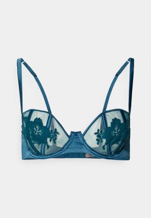 Teal satijnen en mesh bh met bloemafwerking van kant, met beugelcups en verstelbare schouderbanden, plat gelegd op een witte achtergrond.