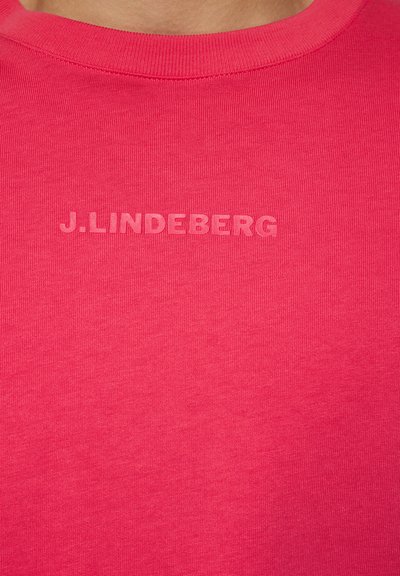 Felt rövidujjú póló élénk rózsaszín pamutból, az elején egy diszkrét domború "J.LINDEBERG" logóval. Sima tapintású.