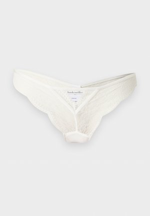 White lace bikini-style women's underwear with scalloped edges, branded label inside, displayed against a plain light background.