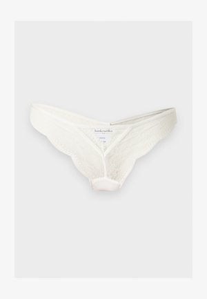 White lace bikini-style women's underwear with scalloped edges, branded label inside, displayed against a plain light background.