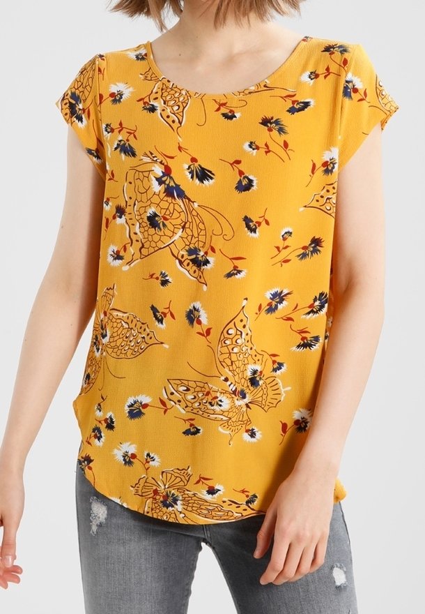 Top giallo a maniche corte con scollo rotondo, decorato con grandi farfalle e piccoli fiori, abbinato a jeans grigi con effetto vissuto.