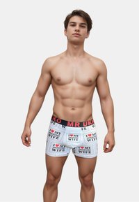 Kalsonger med vit botten, med svart och röd text som säger "JAG ÄLSKAR MIN FRU" och "JAG ÄLSKAR MIN FANTASTISKA FRU," elastisk midja.