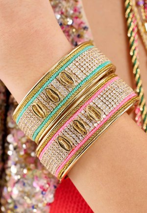 Gold bangles with textured surfaces, featuring pink and turquoise accents, adorned with clear gems and shells. Smooth finish, stacked design.