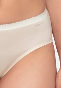Beige Unterwäsche mit einem gewellten Spitzenbund, aus glattem Baumwollmaterial und subtiler Markenkennzeichnung an der Seite. Klassisches Bikini-Cut-Design.