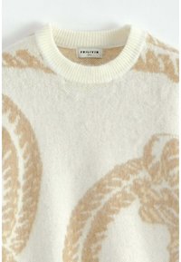 Pull en tricot blanc doux avec des motifs de feuilles décoratifs beiges et un col rond côtelé, taille M étiquetée par Frilivin.
