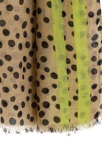 Tela ligera y translúcida con fondo beige, presenta grandes lunares negros y dos franjas verticales en verde neón. Bordes deshilachados.