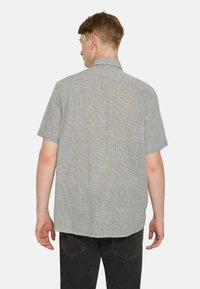 Kurzarmhemd im schwarz-weißen Karomuster. Leichte Stoffqualit�ät, Rückenpasse und lässige Passform.