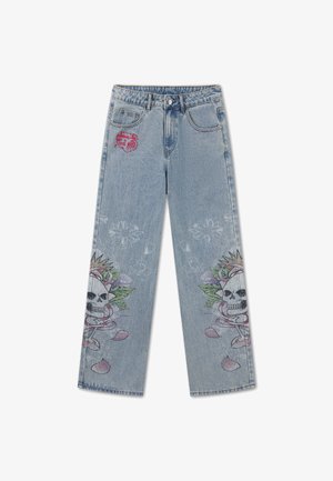 Hellblaue Jeans aus Denim mit weitem Bein, mit Totenkopf- und Blumenmuster in Knienähe und rotem Sticktext auf der oberen linken Tasche.