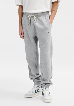 Graue Sweatpants aus weichem Stoff, mit einem elastischen Bund mit Kordelzug, Seitentaschen und einem engen Abschluss an den Knöcheln.