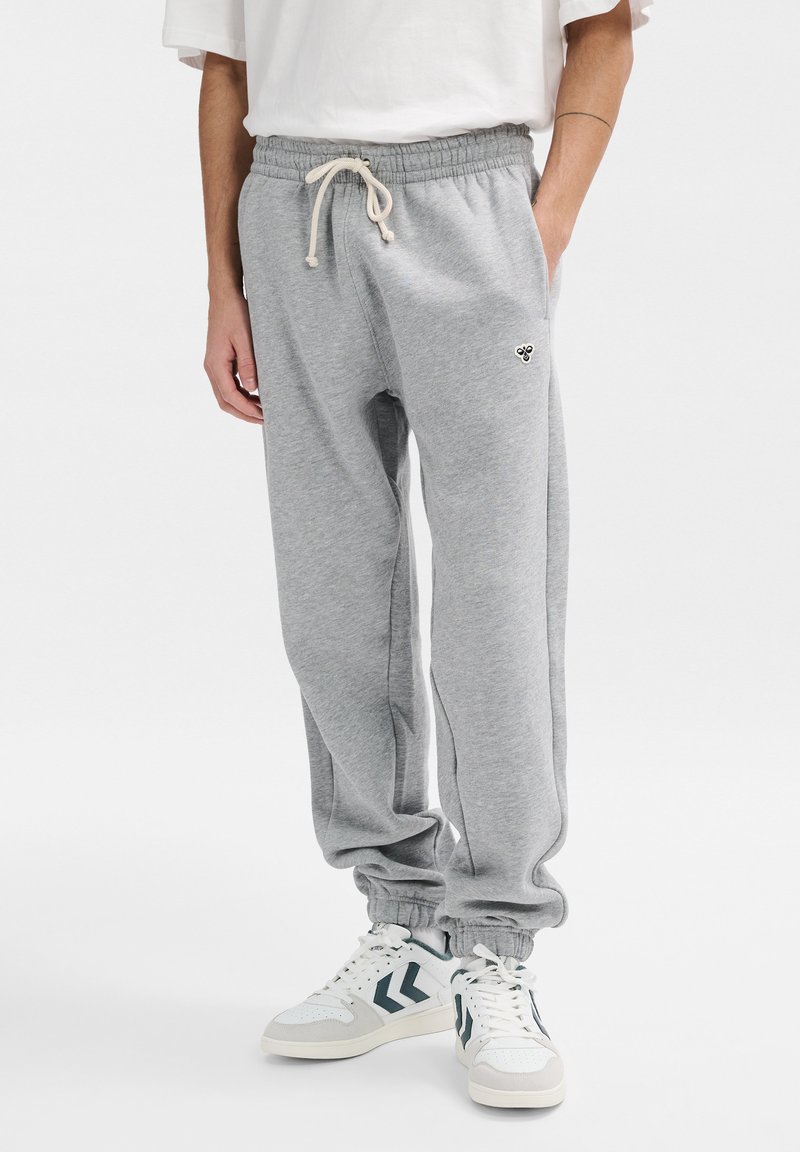 Grijze joggingsbroek van zacht materiaal, met een elastische tailleband met trekkoord, zijzakken en een strakke manchette bij de enkels.