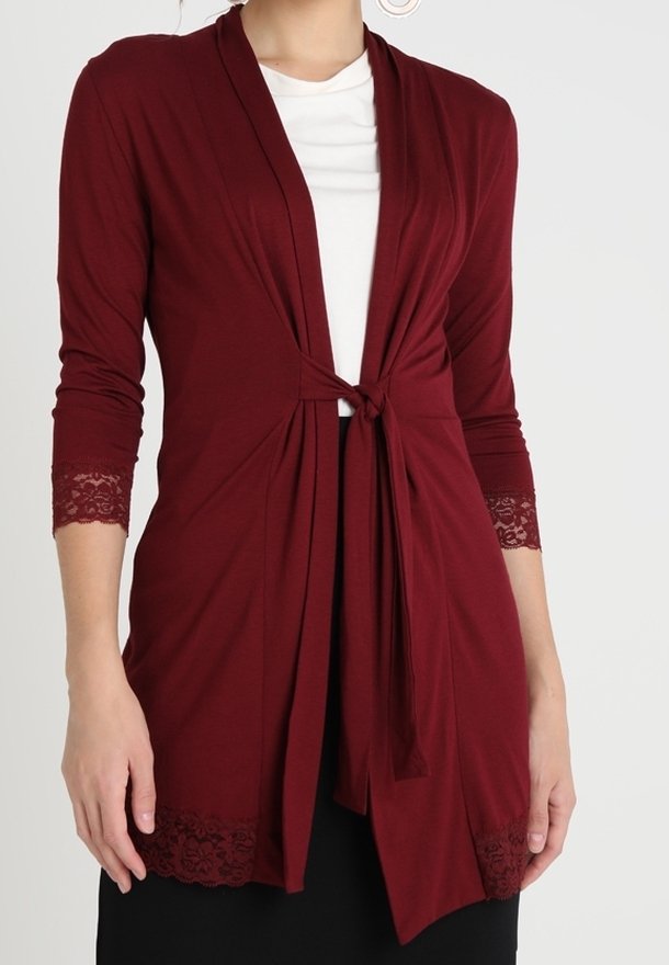 Bordowy kardigan z długimi rękawami, otwartym przodem i wiązaniem. Posiada koronkowe akcenty na rękawach i dole, wykonany z miękkiego, elastycznego materiału.