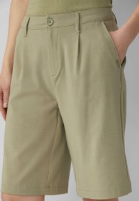 Khaki shorts van textuurstof, met een knoopsluiting, schuine voorzakken en een getailleerde pasvorm met subtiele plooien.