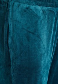 Teal velours stof met een zachte textuur. Beschikt over een gladde oppervlakte met een lichte glans en een zijzak, ideaal voor loungewear.