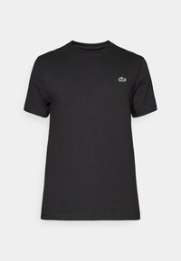 Zwarte katoenen T-shirt met een ronde hals. Heeft een klein groen krokodillenlogo op de linkerborst. Korte mouwen en een standaard pasvorm.