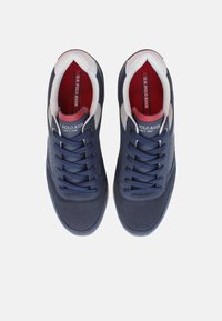 Scarpe in rete blu navy con accenti in pelle bianca, punta tonda e suola in gomma. Presentano lacci piatti e branding sulla linguetta.