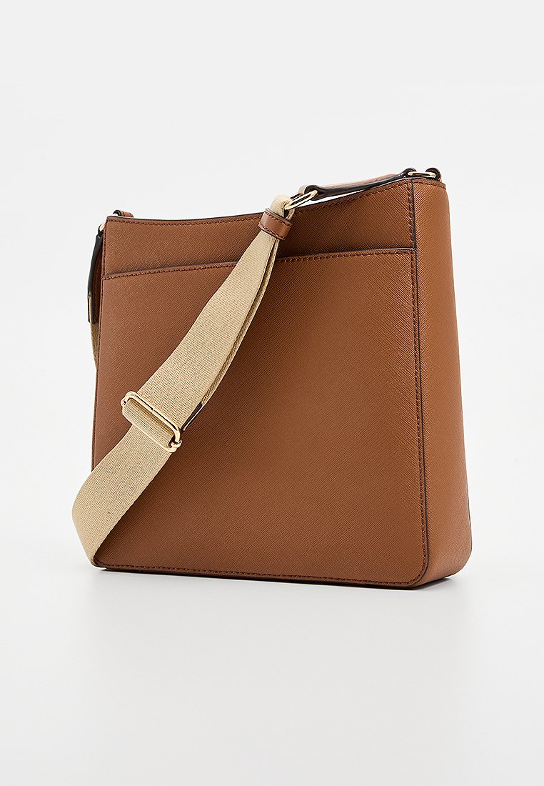 Sac bandoulière en cuir marron avec une finition texturée, une large bandoulière beige, et une forme rectangulaire lisse. Il possède une poche plate à l'arrière.