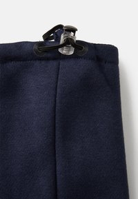 Navyblaue Jogginghosen mit einem Kordelzugverschluss an der Taille, aus weichem Stoff gefertigt, mit glatter Textur und abgerundeten Nähten.