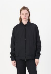 Black bomber jacket with zip front, ribbed collar, and cuffs. Features side pockets and a slightly loose fit, made from smooth fabric.