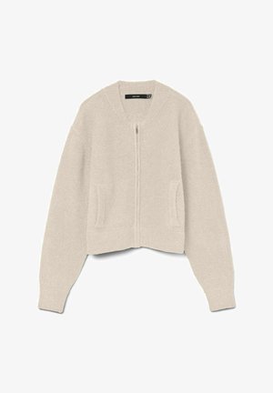 Cardigan court beige avec fermeture éclair, manches côtelées et deux poches latérales. Texture douce avec une coupe décontractée et des manches larges.