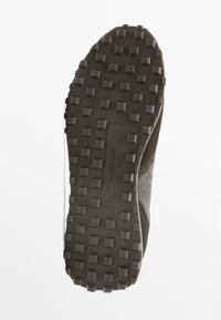 Tmavě šedá podrážka boty s texturovanými, obdélníkovými vzory; obsahuje značení "Massimo Dutti" a velikost "42" vyražené na povrchu.