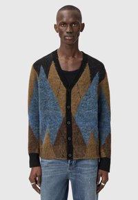 Πολύχρωμη ζακέτα από μείγμα μαλλιού· διαθέτει σχεδιασμό με μοτίβο σε μπλε, καφέ και μαύρα διαμάντια και κλείσιμο με μαύρα κουμπιά.