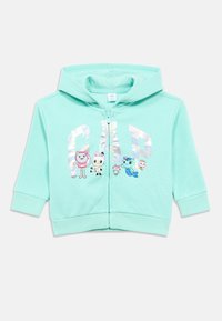 Mäta zelená mikina na zips s klokankovým vreckom a manžetami na rebrovanie. Ozdobená farebnými kreslenými postavičkami a reflexným nápisom "GAP".