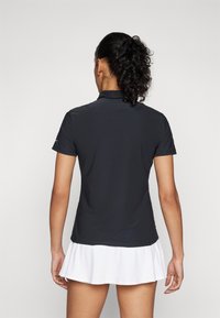 Dark gray polo shirt with short sleeves, featuring a collar and a straight hem, paired with a white flared tennis skirt.