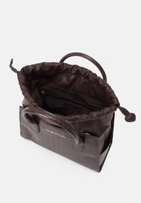 Brun läderhandväska med en texturerad, präglad mönster, öppen design och en snörad topp. Har korta handtag och en intern dragkedjeficka.